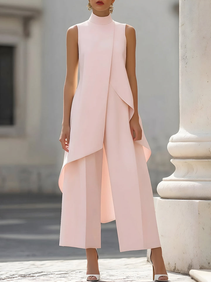 Lichtroze set met asymmetrische mouwloze top en wijde broek, vooraanzicht op een model naast een zuil. 7