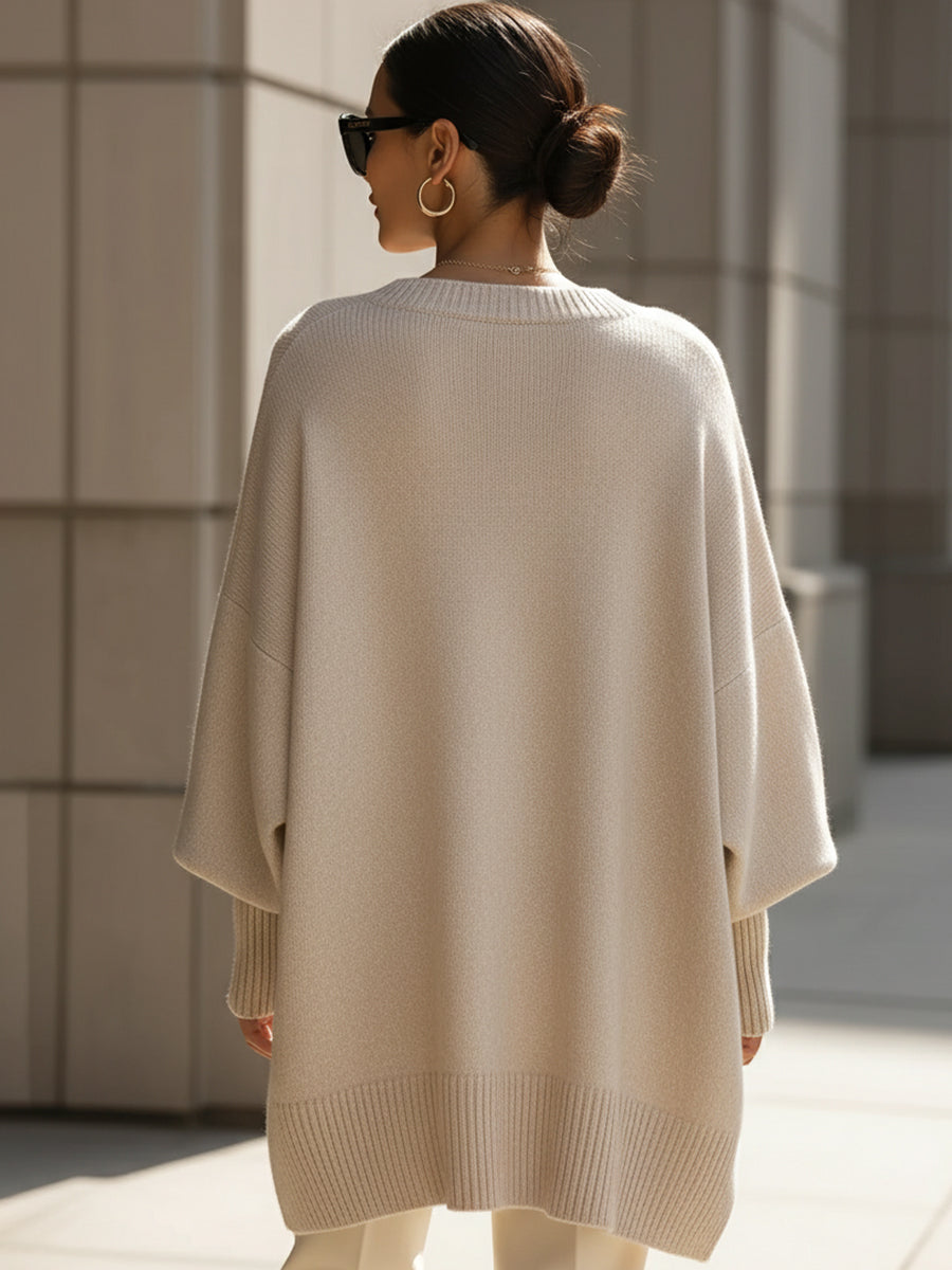 Achterkant van de beige poncho op een model, met brede ribzoom onderaan en wijde mouwen 5
