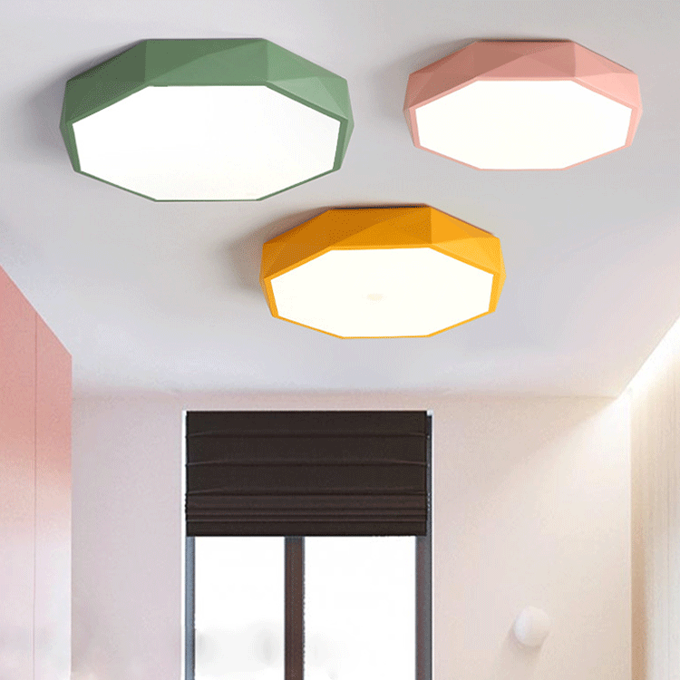 Drie achthoekige plafondlampen in groen, roze en geel aan een plafond bij een raam 1