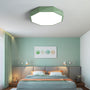 Groene achthoekige plafondlamp boven een bed in een slaapkamer met groenblauwe muur 20