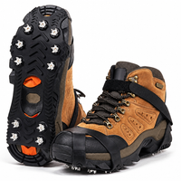 Wandelschoen met zwarte antislipijzers, de zool omhoog met stalen spikes en de klittenbandband zichtbaar 1