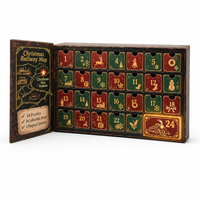 Geopende adventskalender met 24 rood-groene vakjes met kerstsymbolen, links een binnenklep met spoorwegkaart en een gloeiend vak 24 met stoomtrein. 1