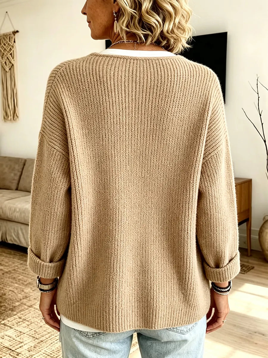 Achterkant van het beige vest gedshowd op een model, met brede ribbels en opgerolde mouwen 2