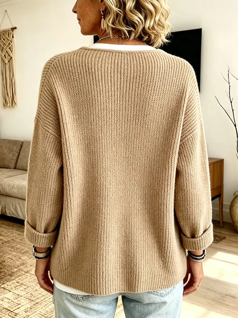 Achterkant van het beige vest gedshowd op een model, met brede ribbels en opgerolde mouwen 2