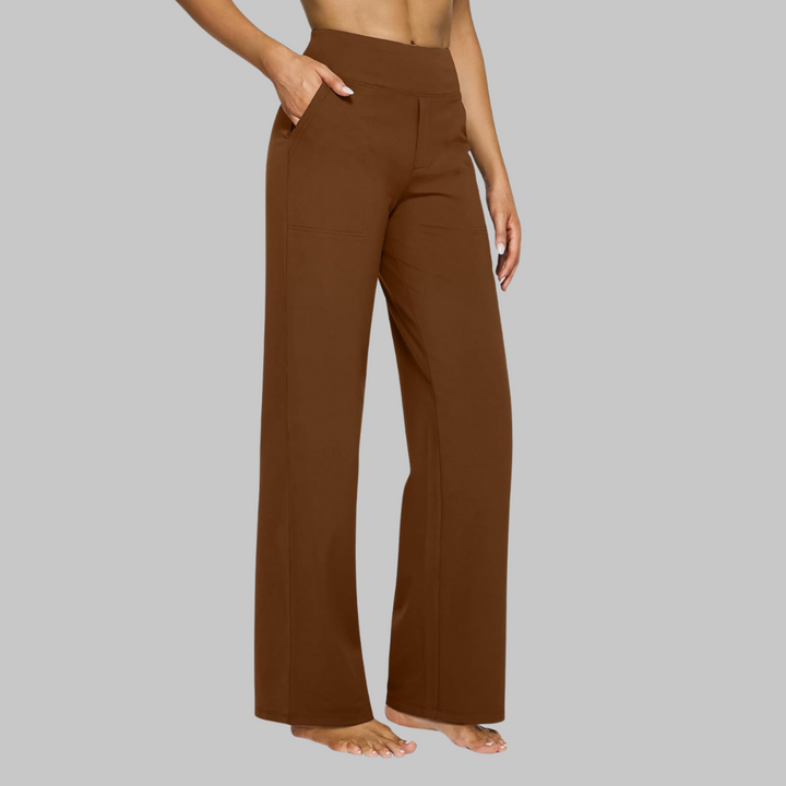 Model in warmbruine broek met hoge taille en rechte pijpen, zijaanzicht met hand in de zijzak. 13