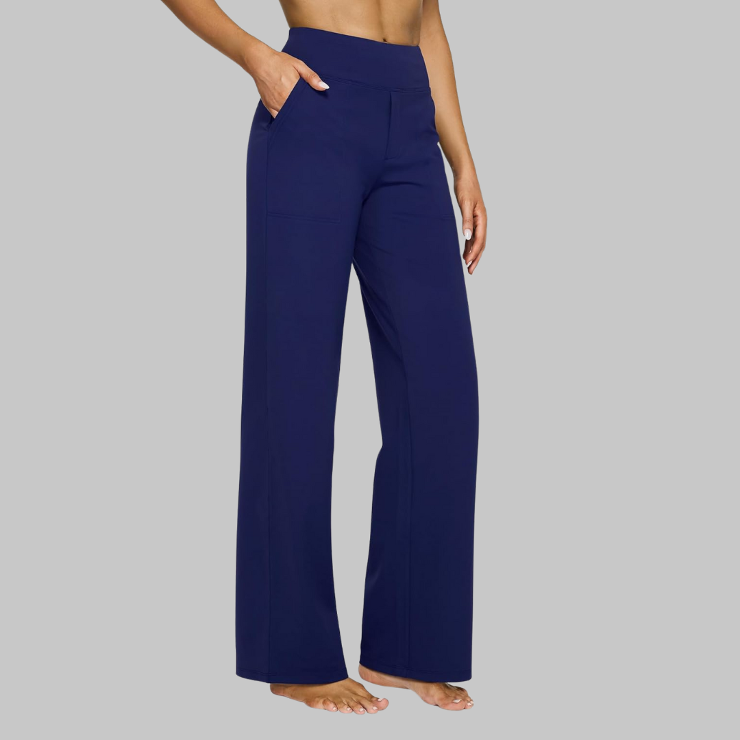 Model in marineblauwe broek met hoge taille en rechte pijpen, zijaanzicht met hand in de zijzak. 12