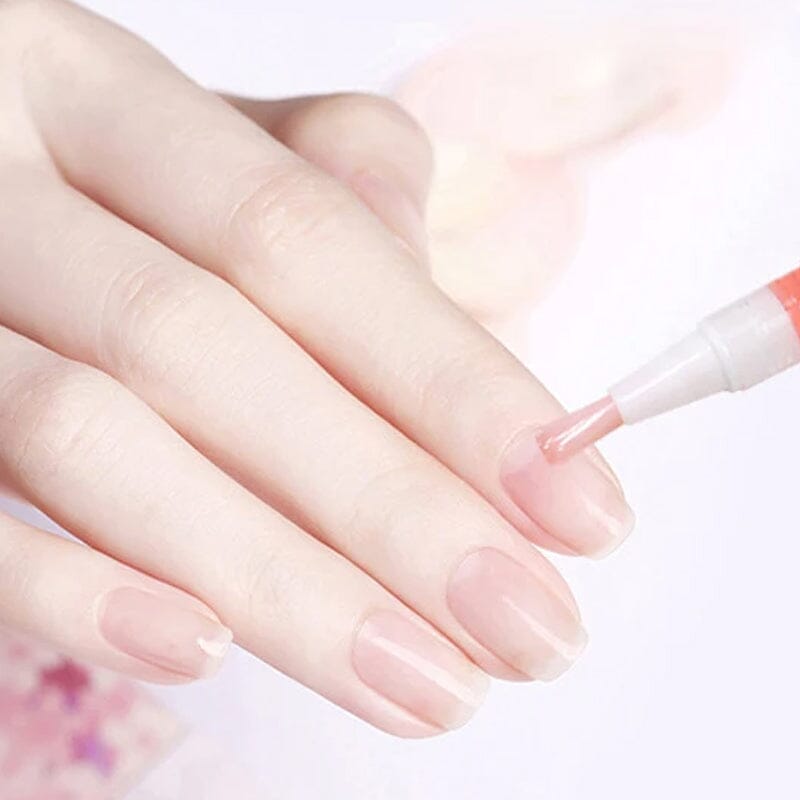Close-up van een hand met roze nagels terwijl een pen met penseel olie op de nagel aanbrengt 11