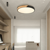 Ronde plafondlamp met zwarte rand en houten deel in een lichte werkkamer met houten wandkast 7