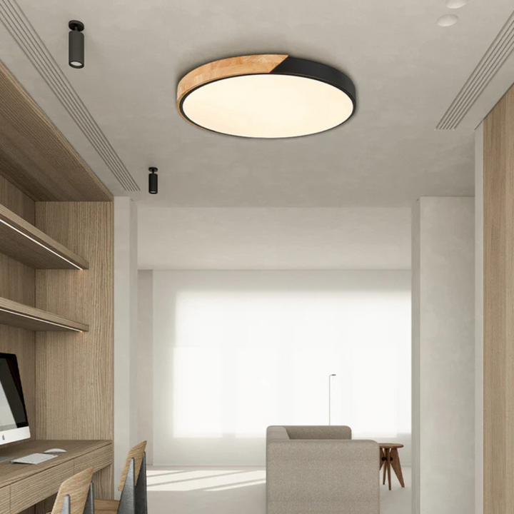 Ronde plafondlamp met zwarte rand en houten deel in een lichte werkkamer met houten wandkast 7