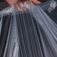 Hand tilt een plooi van het heldere, soepele plastic op, waardoor de dunne transparante folie van dichtbij te zien is. 6