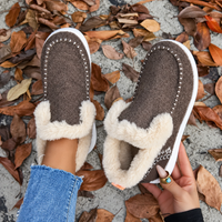 Bruine instapsneakers van bovenaf gezien, met witte stiksels op de neus; de zachte pluchen binnenkant is goed zichtbaar. 8
