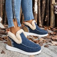 Blauwe instapsneakers met beige pluchen rand, bruin hielstuk en oranje hiellusje, gedragen met spijkerbroek, zijaanzicht van dichtbij. 10