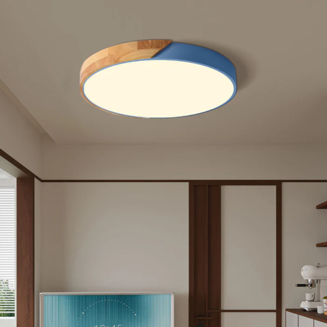 Ronde plafondlamp met houten deel en blauwe rand in een beige woonkamer met houten kozijnen 2