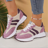 Roze en beige sneakers met paarse strepen en dikke witte zool, zijaanzicht gedragen op een witte sokkel 12