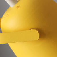 Detail van de mat gele kap met kleine ventilatiegaatjes en de beugel waarmee de kap draait. 3
