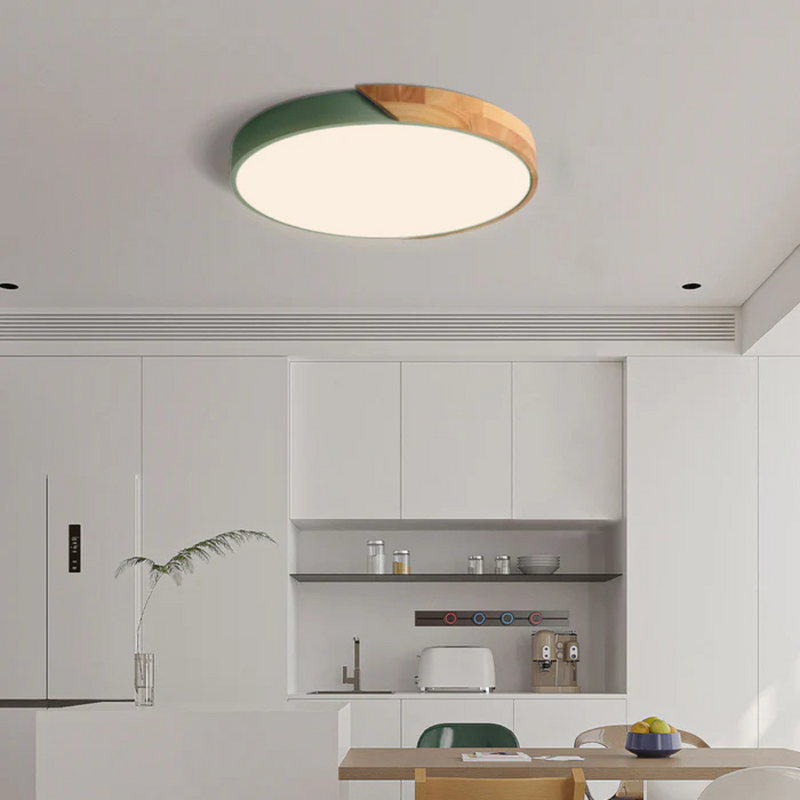 Ronde plafondlamp met groene rand en houten deel boven een witte moderne keuken 3