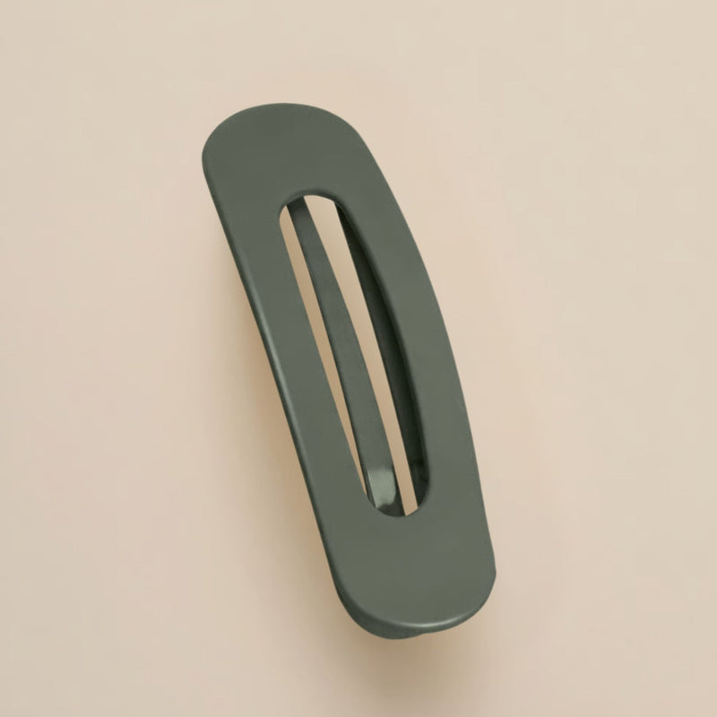Matte donkergroene haarclip met ovale opening, schuin van boven gefotografeerd op een beige achtergrond 16