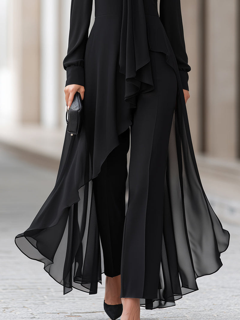 Detail van de onderkant: de asymmetrische, doorschijnende chiffon zoom van de tuniek valt over de wijde zwarte broekspijpen. 4