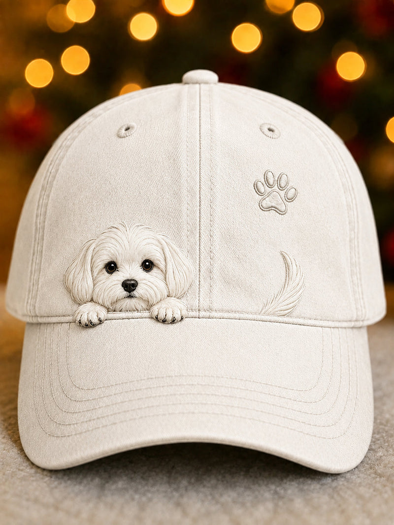 Voorkant van de pet in gebroken wit, met een witte pup die over de rand kijkt, een pootafdruk en een staartje. 1