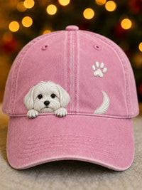 Voorkant van de pet in roze met dezelfde pup, pootafdruk en kwispelend staartje, voor een warme lichtjesachtergrond. 2