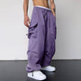 Baggy cargobroek in paars aan een model met witte sneakers, schuin van voren gefotografeerd 5