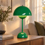 Glanzend groene tafellamp met koepelkap en lichtgevende bol, op een houten kast in de woonkamer 8
