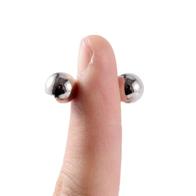 Twee zilverkleurige magneetbolletjes houden aan weerszijden van een vingertop vast om te laten zien hoe klein ze zijn. 7