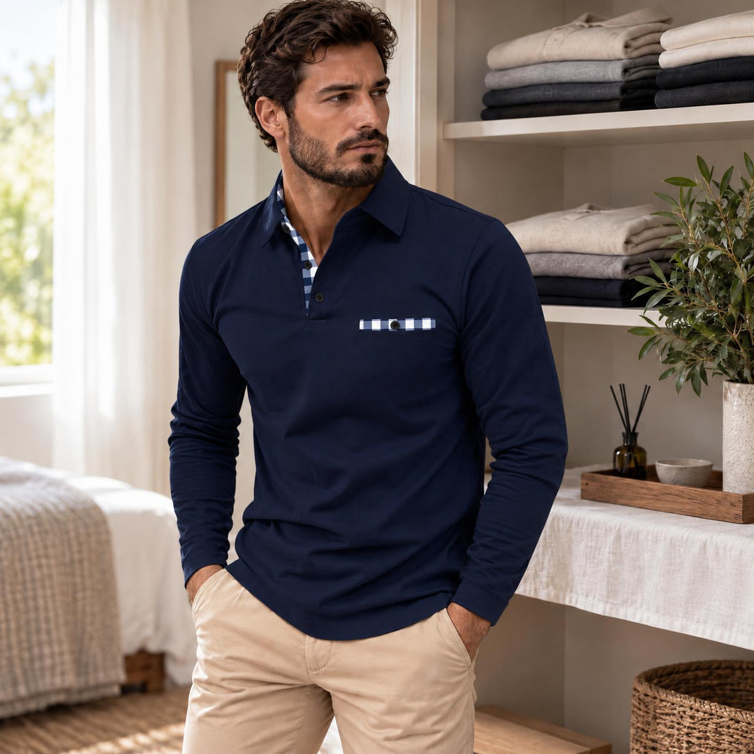 Model draagt de marineblauwe polo met blauw-wit geruit zakje en kraagrand, staand bij een open kast 3