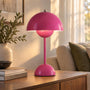 Glanzend roze versie van de tafellamp met lichtgevende bol onder de kap, op een houten kast 10