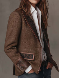 Model draagt de blazer schuin van opzij, met patroonvoering zichtbaar langs de revers en gestreepte manchet 9