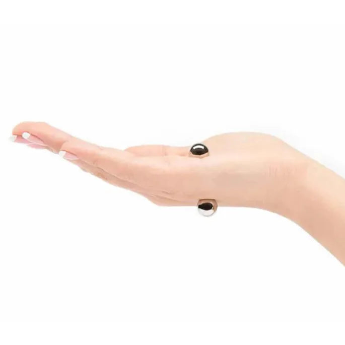 Zijaanzicht van een open hand met twee zilverkleurige bolletjes die door magnetische kracht aan beide kanten van de huid zitten. 9
