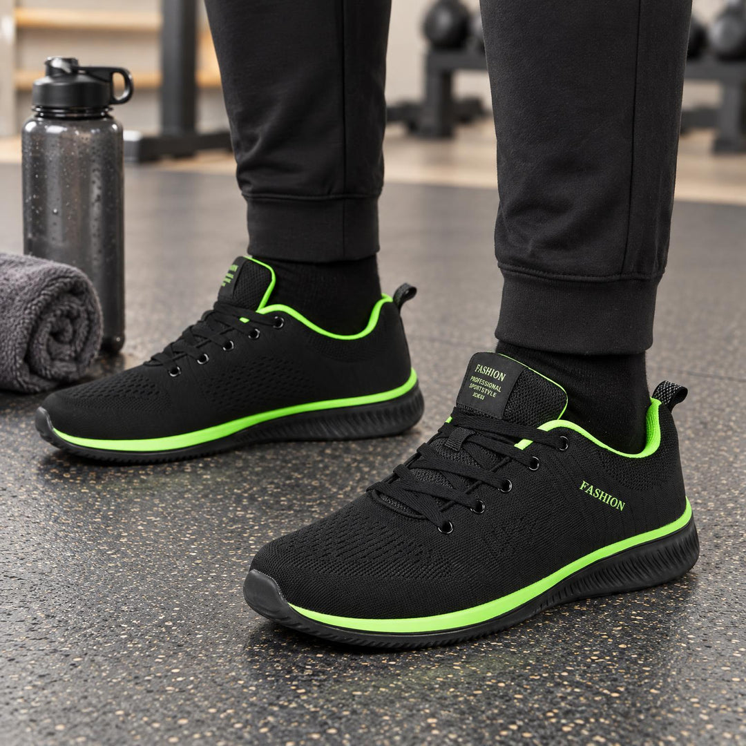 Zwarte gebreide sneakers met felgroene accenten langs de zool en de binnenrand, gedragen in de sportschool 4