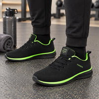Zwarte gebreide sneakers met felgroene accenten langs de zool en de binnenrand, gedragen in de sportschool 4