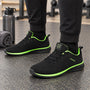 Zwarte gebreide sneakers met felgroene accenten langs de zool en de binnenrand, gedragen in de sportschool 4