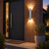 Witte uitvoering van de wandlamp op bakstenen gevel naast de zwarte voordeur, met op- en neerwaarts licht 3