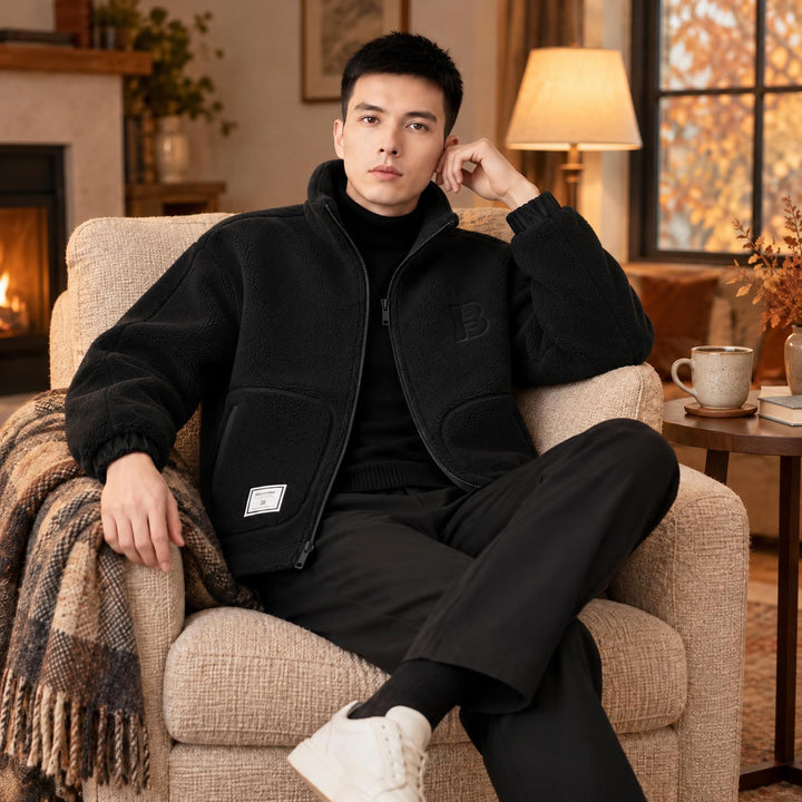 Man in zwart fleece vest met open rits, ontspannen in een fauteuil bij de open haard 2