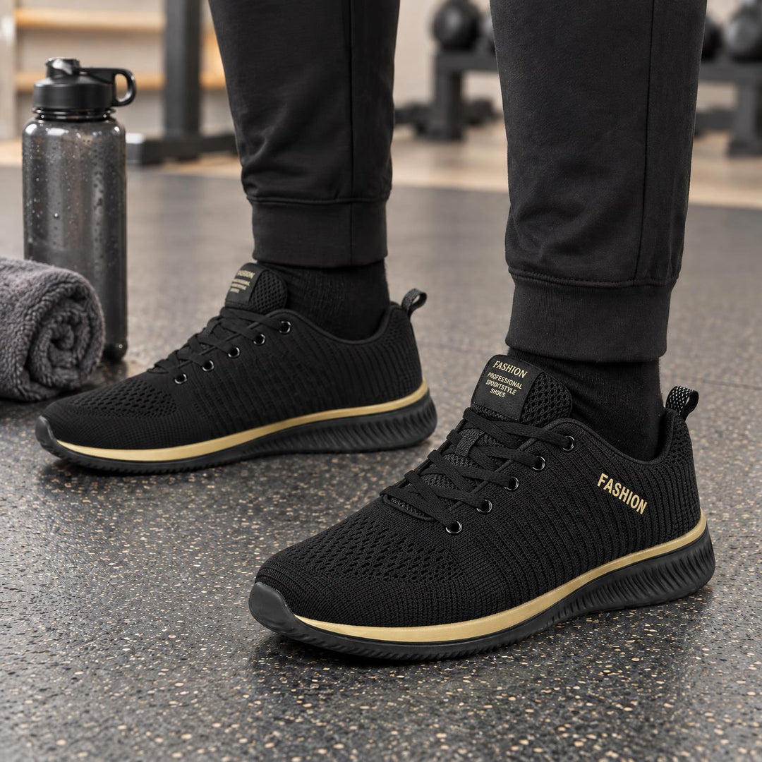 Zwarte gebreide sneakers met goudkleurige zoolstrook en gestreept breipatroon, gedragen in de sportschool 5