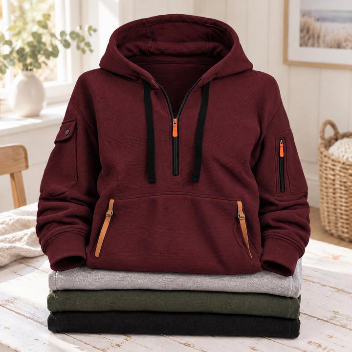 Bordeauxrode hoodie met halve rits en oranje bandjes aan de zak, op gevouwen truien 7