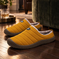 Okergele gewatteerde pantoffels met pluche voering en bruine zool in een sfeervolle woonkamer 5