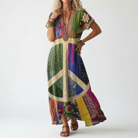 Model draagt de jurk in kleurrijke patchworkstijl met een groot vredesteken in crème op de voorkant, met bruine sandalen en kralenkettingen. 2
