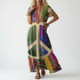 Model draagt de jurk in kleurrijke patchworkstijl met een groot vredesteken in crème op de voorkant, met bruine sandalen en kralenkettingen. 2