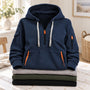 Marineblauwe hoodie met halve rits en kangoeroezak, bovenop een stapel gevouwen truien 2