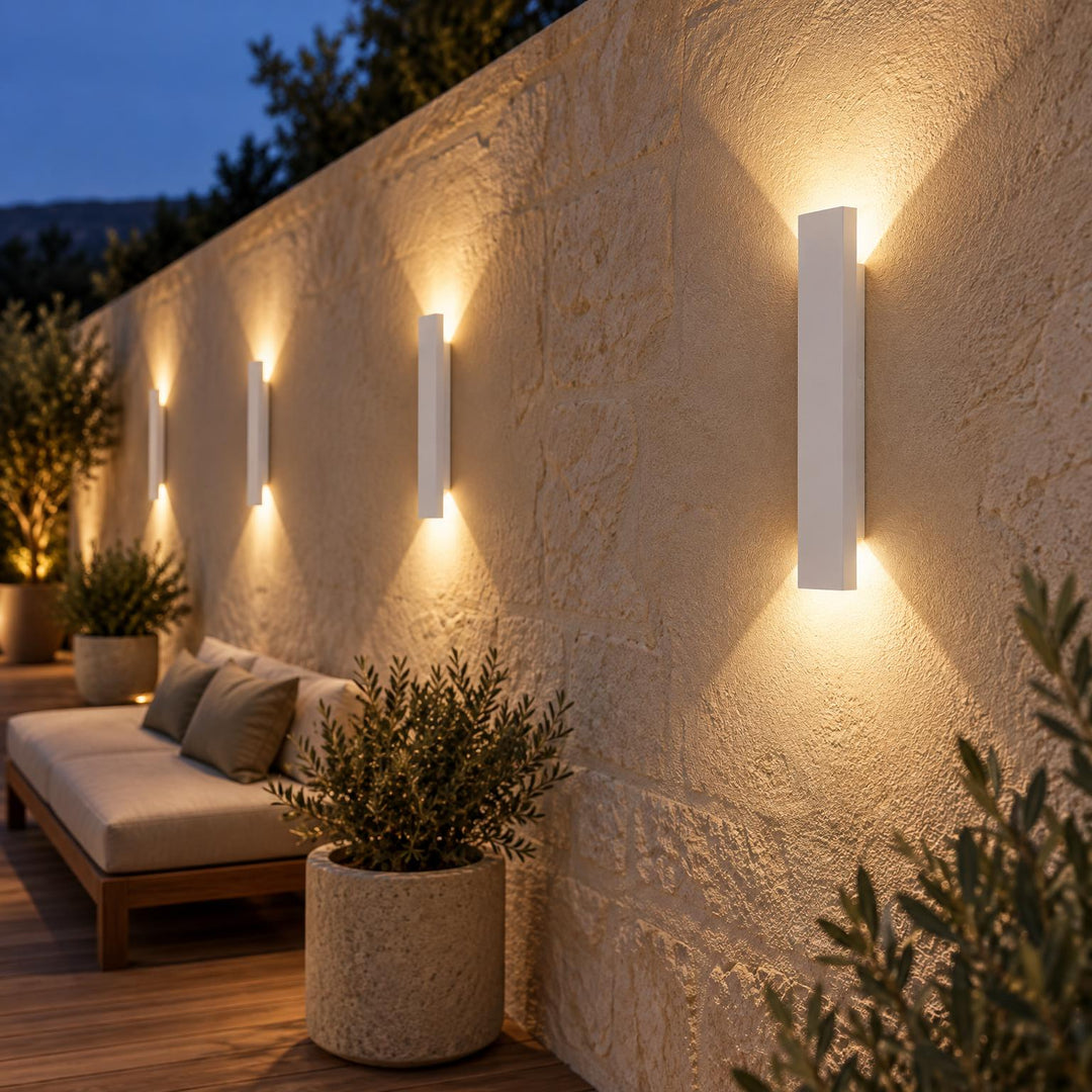 Witte uitvoering van de wandlampen, verlicht in de avond op een beige muur met loungebank 3