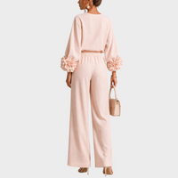 Achterkant van de roze set op een model, met bloemen aan de mouwen en elastische taille 8