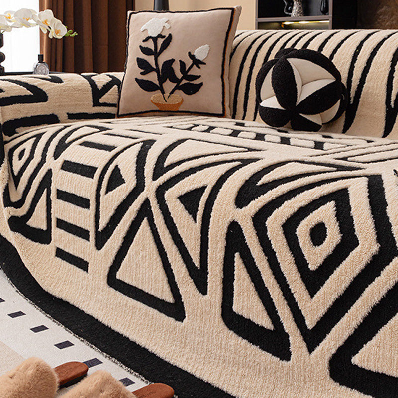 Beige bankhoes met zwart geometrisch patroon van driehoeken en ruiten, met bloemenkussen en ronde kussenbal 17