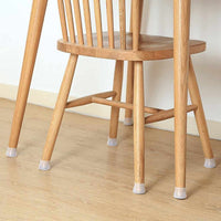 Houten stoel op een houten vloer met een doorschijnend siliconen dopje onder elke poot. 5
