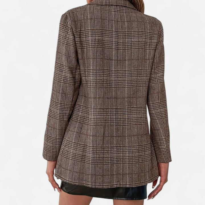 Close-up van de achterzijde van de bruine blazer met ruitpatroon, gedragen met een zwarte rok, met lange mouwen en getailleerde snit. 4
