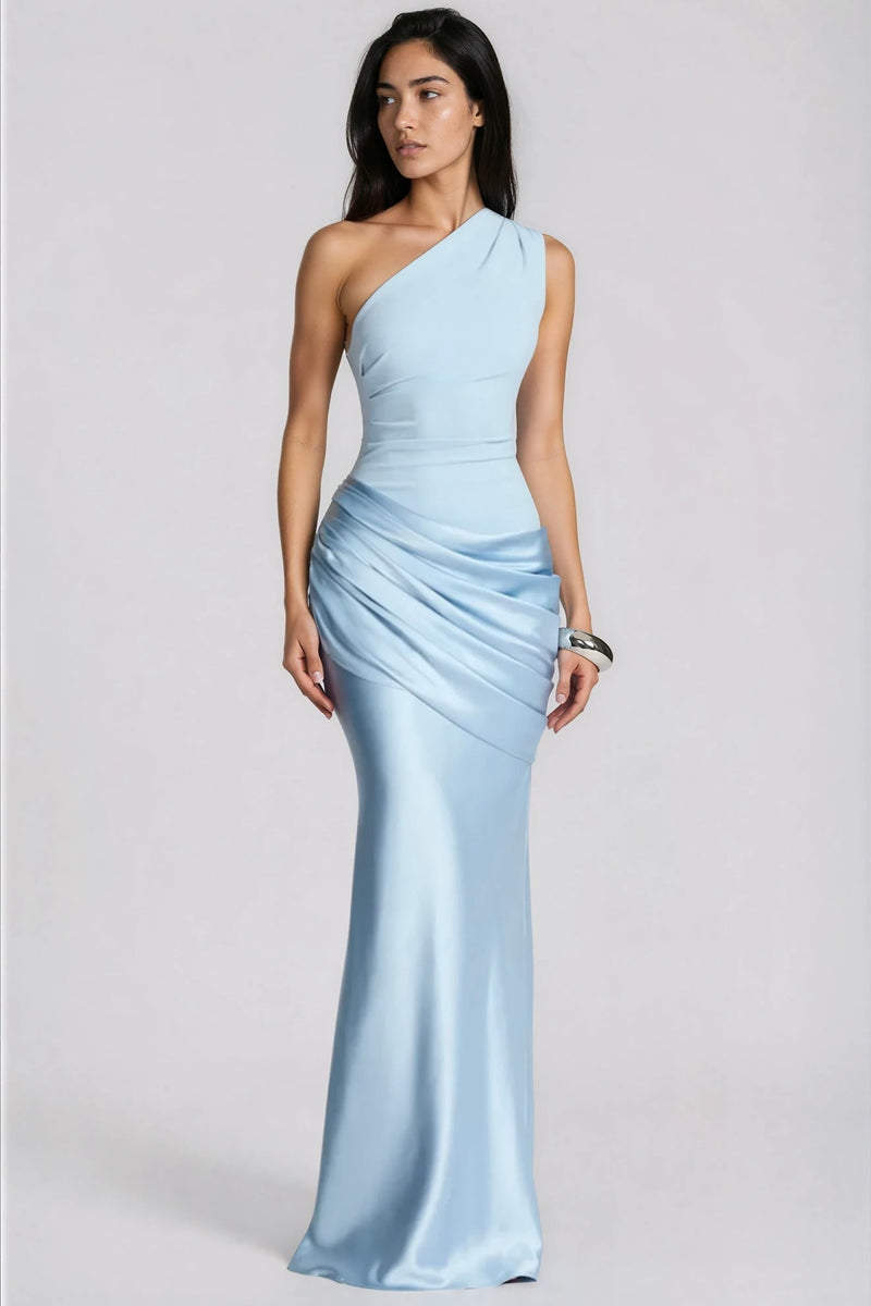 Model in lichtblauwe maxi-jurk met één schouder en gedrapeerde satijnen heup, frontaal in beeld met zilveren armband. 1