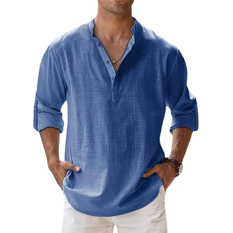 Man draagt het henleyshirt in blauw met knoopsluiting, opgerolde mouwen en een witte broek, vooraanzicht. 2
