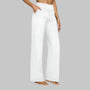 Model in witte broek met hoge taille en wijde rechte pijpen, zijaanzicht met hand in de zijzak. 8